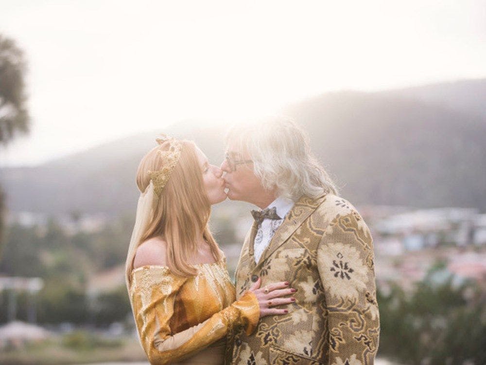 David and Kirsha kissing on their wedding day. The sun getting low behind them on the mountain range.