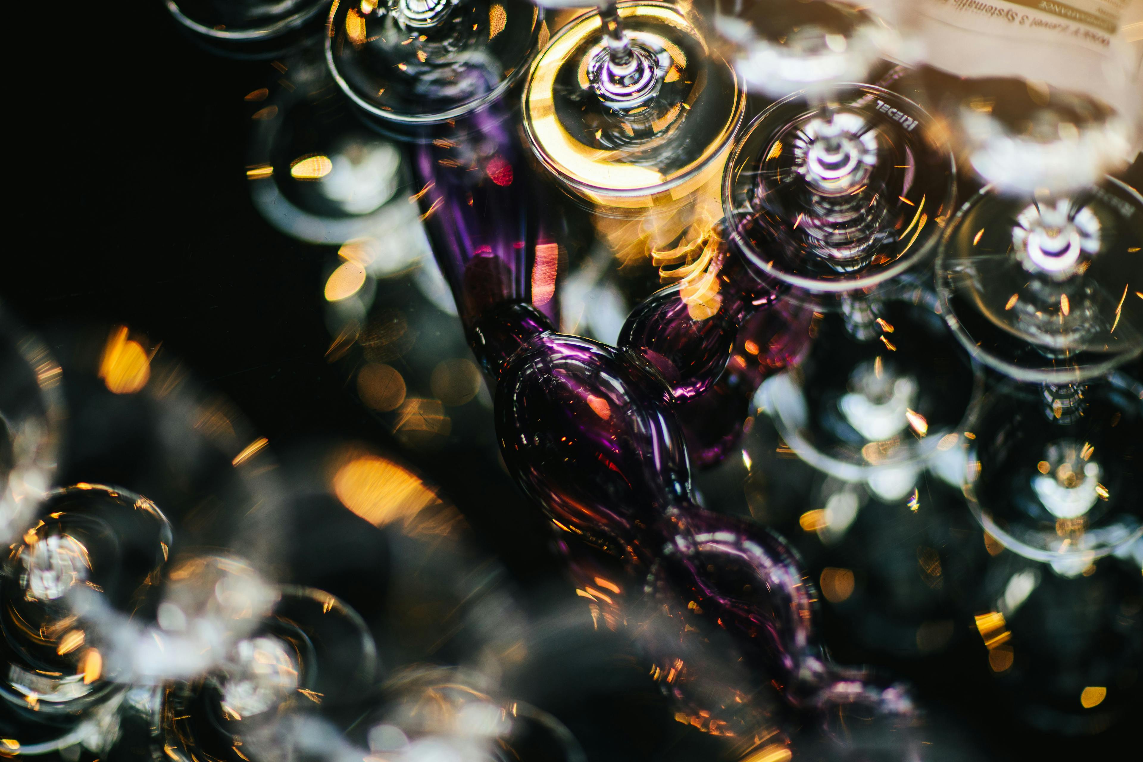 Wine glasses sit on top of a table with colourful reflections